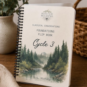 May include: A spiral-bound flip book titled Classical Conversations Foundations Flip Book Cycle 3 U.S. History. The cover features a Rooted Wilding logo and a watercolor illustration of a river flowing through a dense green pine forest.