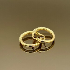 May include: A pair of gold hoop earrings with a textured surface.