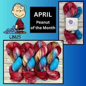 May include: An image featuring colorful yarn skeins with red, blue, and tan hues. The text "APRIL Peanut of the Month" is displayed, along with a cartoon illustration of Linus from Peanuts.