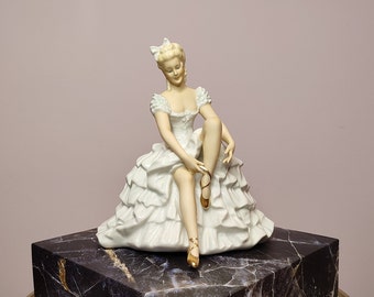 Graceful statuette of a ballet dancer tying pointe shoes, Schaubach-Kunst Porzellanmarke, Germany, Thuringia, 1953-1962.