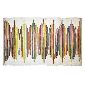 May include: A rectangular woven rug featuring a white base with a repeating vertical pattern of multicoloured fabric strips. The strips include shades of green, yellow, pink, blue, brown, and red, arranged in a jagged, leaf-like design across the surface.