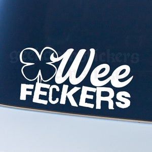 May include: White vinyl sticker with a four-leaf clover and the text "Wee Feckers".