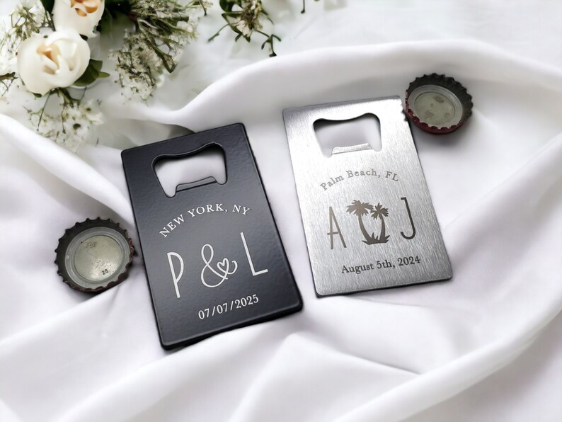May include: Two rectangular bottle openers, one black and one silver, with personalized text. The black opener reads "NEW YORK, NY" and "P & L" with a date. The silver opener says "Palm Beach, FL", initials, and a date.