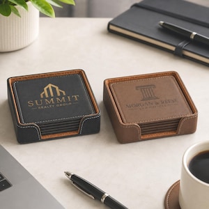 May include: Two square leather coaster sets in holders. The black set features the gold logo Summit Realty Group. The brown set features the black logo Morgan & Reese Law Offices. Both sets have visible stitching and stacked square coasters inside.