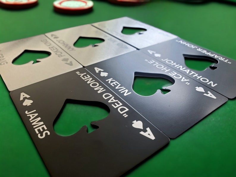 May include: A set of rectangular metal bottle openers shaped like playing cards, featuring a die-cut spade symbol in the centre. Each opener is engraved with an ace of spades icon, a unique name, and a nickname, including James, Kevin, and Johnathon.