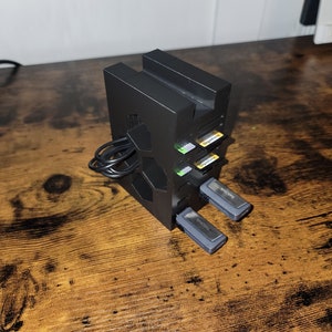 May include: A black plastic storage stand with multiple slots for memory cards and USB drives. The stand is holding several memory cards and two USB drives, one labeled "SanDisk" and the other "Kingston".