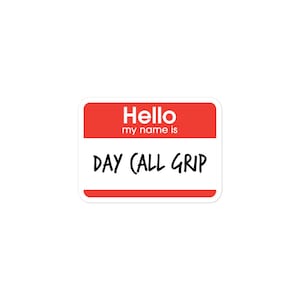 May include: Red and white name tag sticker with the text "Hello my name is DAY CALL GRIP"
