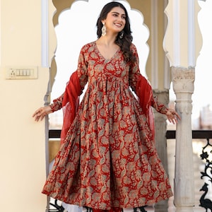 Puede incluir: Un vestido rojo con estampado floral con pantalones y bufanda a juego. El vestido tiene cuello en V y mangas largas. El conjunto est&aacute; hecho de una tela ligera y es adecuado para climas c&aacute;lidos. Es un estilo tradicional indio.