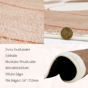 May include: A close-up of a brown faux cashmere rug with a white edge. The rug is machine washable and has an anti-skid bottom. The pile height is 0.4 inches or 11.2 millimeters.