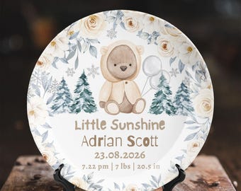May include: A round decorative plate featuring a watercolor illustration of a teddy bear in a hooded outfit, pine trees, and cream-colored roses. The text reads Little Sunshine, Adrian Scott, 23.08.2026, 7.22 pm, 7 lbs, and 20.5 in.