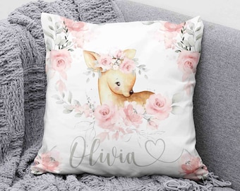 May include: White pillow with a pink floral design and a fawn wearing a flower crown. The name "Olivia" is written in cursive on the pillow.