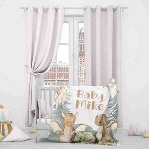 May include: A white baby blanket with a brown and green woodland design featuring dragons and the text "Baby Mike".