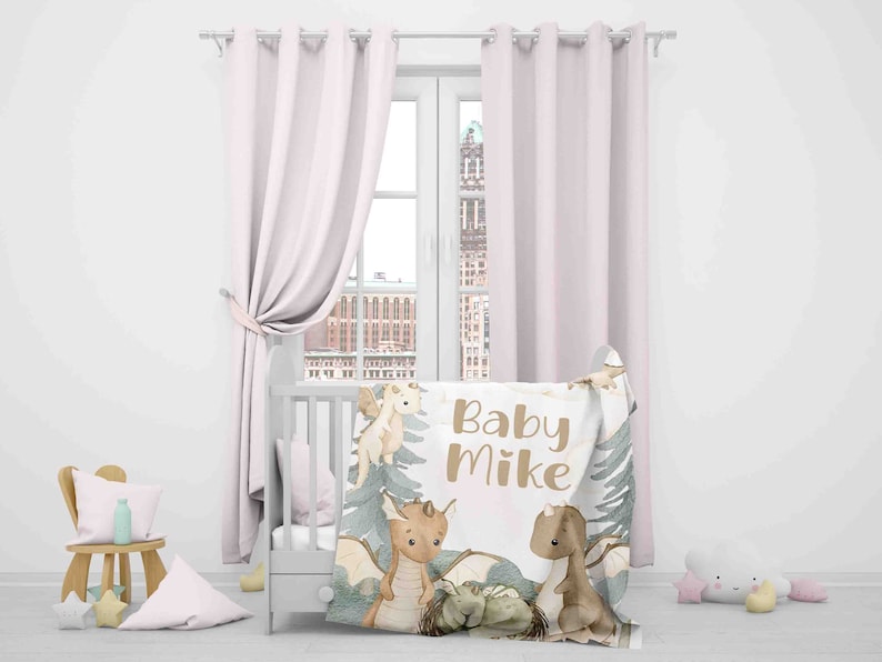 May include: A white baby blanket with a brown and green woodland design featuring dragons and the text "Baby Mike".