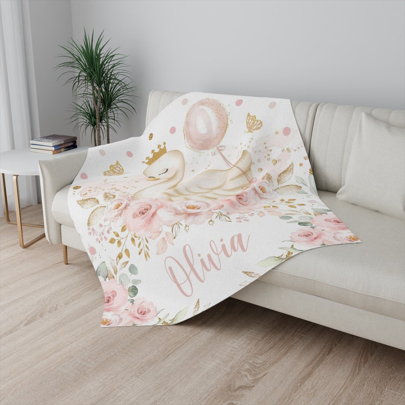 May include: A white and gold swan with a pink crown and a pink balloon is surrounded by pink flowers and gold glitter. The name Olivia is written in pink script below the swan.