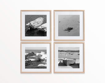 Puede incluir: Un conjunto de cuatro fotografías en blanco y negro enmarcadas. Las imágenes representan escenas costeras: barcos en el agua, una playa arenosa con algas, olas rompiendo contra las rocas y barcos en un puerto. Los marcos son de madera clara.