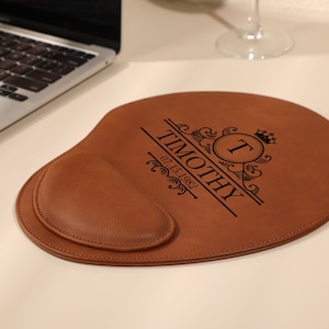 May include: Brown leather mouse mat with a personalised monogram and the name "Timothy" and the date "07.15.1982" engraved on it.