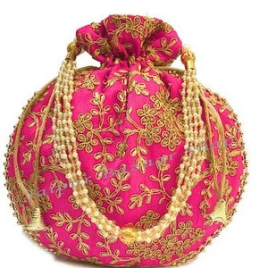 Może przedstawiać: Różowa, okrągła torebka ze złotym haftem kwiatowym. Torebka posiada pasek z koralików i złote frędzle. Dekoracyjny dodatek.