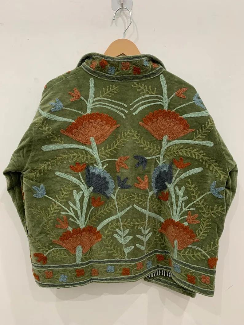 Pu&ograve; includere: Giacca verde oliva con ricami floreali dettagliati nei toni dell'arancione, blu e verde. La giacca presenta un collo e una vestibilit&agrave; rilassata. I ricami sono dettagliati e coprono la schiena della giacca, creando un'estetica boh&eacute;mien.