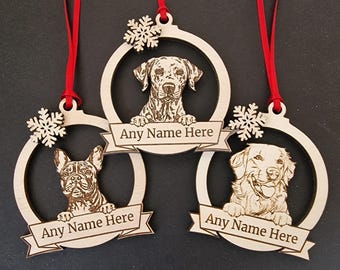 May include: Three wooden Christmas baubles featuring a snowflake design and a dog breed image in each. Each bauble has a red ribbon and a banner that says "Any Name Here".
