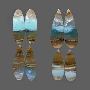 May include: Six oval and teardrop shaped cabochons of polished, layered agate with blue, brown, and white colors.