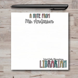 May include: A white note pad with the text "A note from Ms. Anderson" at the top and "West Lake Elementary LIBRARIAN" at the bottom. The text is in a colorful, outlined font.