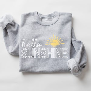 May include: Gray sweatshirt with a white outline of the text "hello sunshine" and a yellow sun graphic.