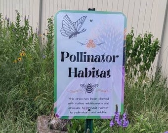 May include: A sign in a garden with a butterfly and bee design reads "Pollinator Habitat". The sign explains that the area has been planted with native wildflowers and grasses to provide food and shelter for pollinators and wildlife.