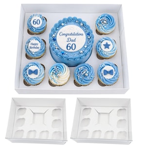 Könnte beinhalten: Ein blauer Kuchen und Cupcakes in einer weißen Box. Der Kuchen ist mit dem Text "Herzlichen Glückwunsch Papa 60" verziert. Die Cupcakes haben blaues Frosting und verschiedene Dekorationen, darunter Fliegen und Sterne. Die Box enthält zwei leere Boxen.