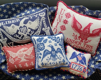 May include: Five embroidered pillow covers with patriotic themes. The pillows feature red, white, and blue colors and images of eagles, stars, and the words "Liberty", "United", "Under This We Prosper", "Eagle", and "1776".