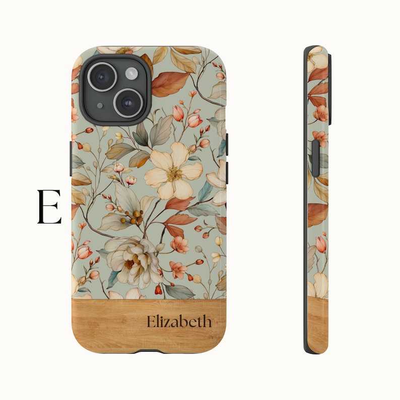 Puede incluir: Una funda de tel&eacute;fono floral con fondo verde claro y base de madera. La funda tiene un patr&oacute;n floral con flores blancas, rosas y naranjas. La base de madera tiene el nombre "Elizabeth" grabado.