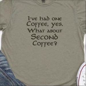 May include: A light green t-shirt with a brown graphic that reads "I've had one coffee, yes. What about second coffee?"