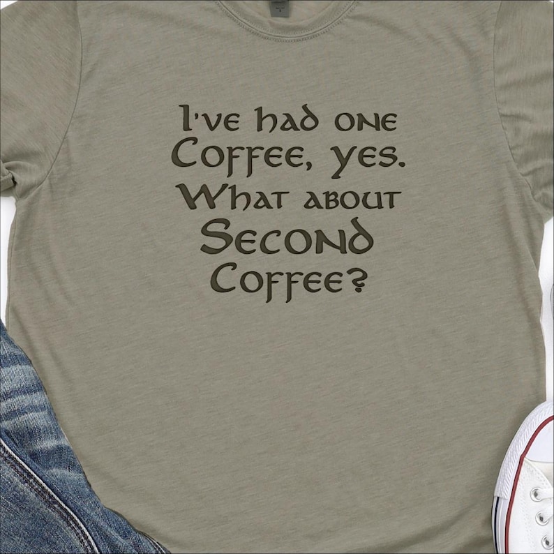 May include: A light green t-shirt with a brown graphic that reads "I've had one coffee, yes. What about second coffee?"