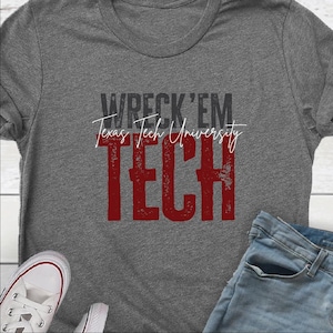May include: Gray t-shirt with the text "WRECK 'EM Texas Tech University TECH" in black and red. The shirt is paired with blue jeans and white sneakers.