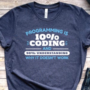 May include: A navy blue t-shirt with white text that reads "Programming is 10% coding and 90% understanding why it doesn't work".