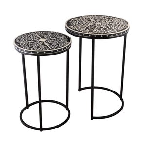 May include: Two black side tables with white floral inlay on the tabletop. The tables have black metal legs and a round design. The smaller table is 46 cm in diameter, and the larger table is 61 cm in diameter.