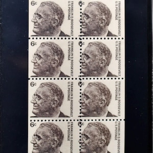 May include: A sheet of four 6-cent United States postage stamps featuring a portrait of Franklin D. Roosevelt. The stamps are beige with black and white details.