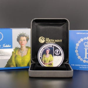 May include: A commemorative coin from The Perth Mint, featuring Queen Elizabeth II, displayed in a presentation box. The coin is in a black case, with a blue box and certificate of authenticity. The coin is for the Diamond Jubilee.