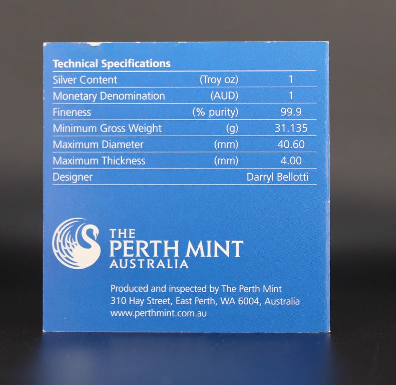 May include: A blue card with technical specifications for a silver product. The card lists details such as silver content, monetary denomination, fineness, minimum gross weight (31.135g), maximum diameter (40.60mm), and maximum thickness (4.00mm). The Perth Mint logo is visible.