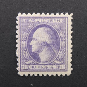 May include: A vintage 3-cent US postage stamp featuring a profile portrait of George Washington in purple. The stamp has a decorative border with a laurel wreath and the text "U.S. POSTAGE" at the top.