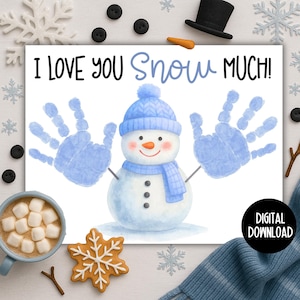 以下が含まれることがあります： 雪だるまのイラストと「I LOVE YOU Snow MUCH！」の文字が入った冬をテーマにしたグリーティングカード。雪だるまは青い帽子とスカーフ、手形のアームを持っています。ホットチョコレートのマグカップと雪の結晶クッキーも表示されています。