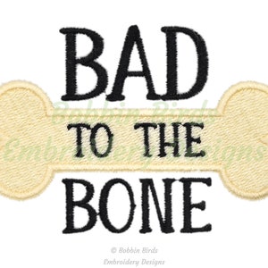 Può includere: Disegno ricamato di un osso di cane con il testo "BAD TO THE BONE" in lettere nere.