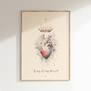 May include: A watercolour painting of a heart with a crown above it. The heart is red and pink, and the crown is gold. The background is a light blue and white watercolour wash. The text "King of my Heart" is written below the heart.