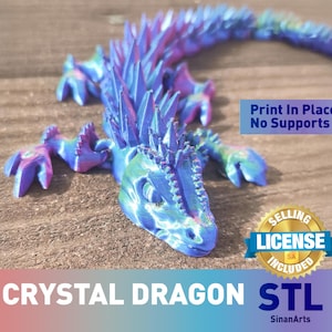 May include: A multi-colored crystal dragon figurine with a detailed design. The dragon is primarily blue, purple, and green, with a textured surface. The text "Print In Place No Supports" and "Crystal Dragon STL" are visible.