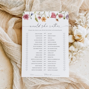 May include: A printable "Would She Rather" bridal shower game with a floral design. The game features a list of 20 questions with two choices each. The questions are designed to help guests get to know the bride-to-be better.