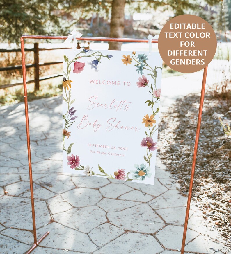 Pu&ograve; includere: Un cartello rettangolare bianco appeso a una cornice di rame, decorato con un bordo floreale ad acquerello colorato. Il testo recita: WELCOME TO, Scarletts, Baby Shower, SEPTEMBER 16, 20XX, San Diego, California. Un cerchio marrone contiene il testo: EDITABLE TEXT COLOR FOR DIFFERENT GENDERS.