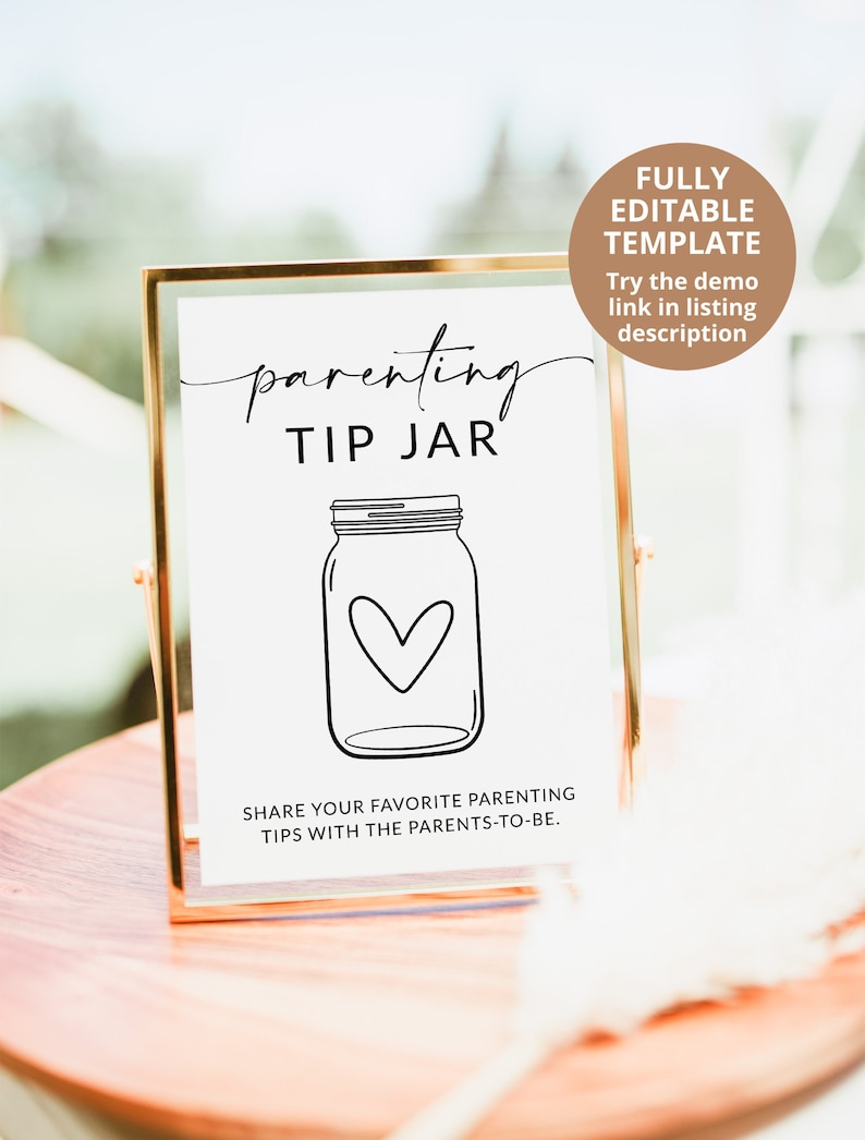 May include: A printable sign in a gold frame that says "parenting tip jar" with a drawing of a mason jar with a heart inside. The sign is on a wooden table.