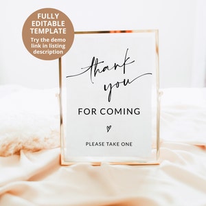 May include: A gold-framed sign with the text "thank you for coming" and a heart symbol. The sign also says "Please take one".