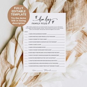 May include: A white paper game sheet titled Baby Family Feud with black text, featuring thirteen numbered questions about baby-related topics, a points column, and lines for a name and total score, accented by two small hand-drawn hearts.