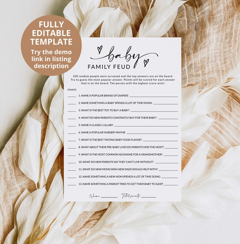 May include: A white paper game sheet titled Baby Family Feud with black text, featuring thirteen numbered questions about baby-related topics, a points column, and lines for a name and total score, accented by two small hand-drawn hearts.