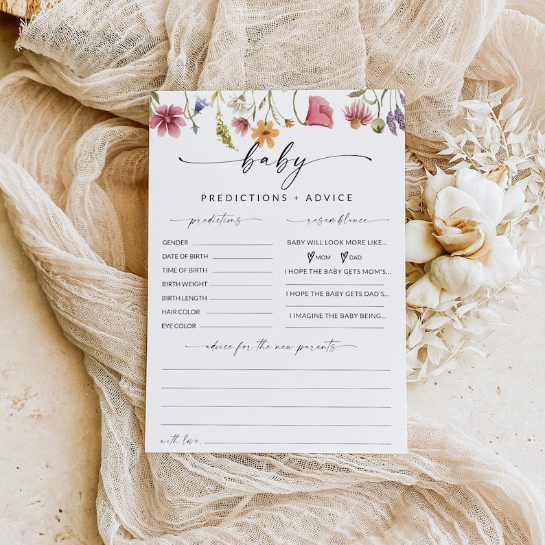 May include: A white card with a floral border and the text "baby predictions + advice". The card has a list of predictions and advice for new parents, including gender, date of birth, time of birth, birth weight, birth length, hair color, eye color, and resemblance to the parents.
